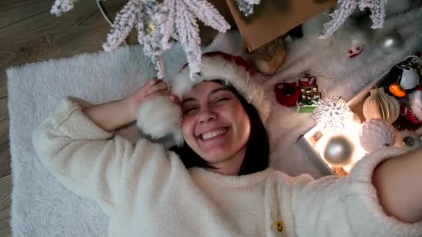 Glückliche Frau Macht Selfie Mit Weihnachtsmütze Und Legt Sich Unter — Stockvideo