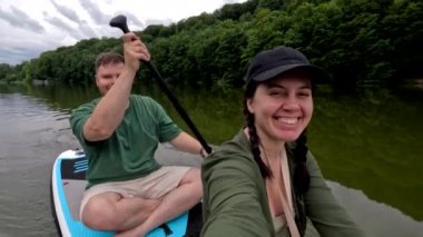 Nehir kenarında yüzen gülümseyen çift.