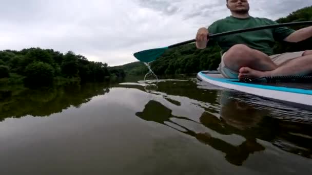 パドルボードの落ち着いた水にハッピーマンパドリング — ストック動画