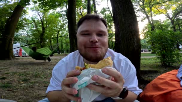 Man Dicht Eten Hamburger Buiten — Stockvideo