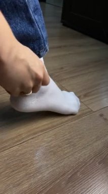 Kadın ayaklarına çorap geçirmiş. Yaklaş.