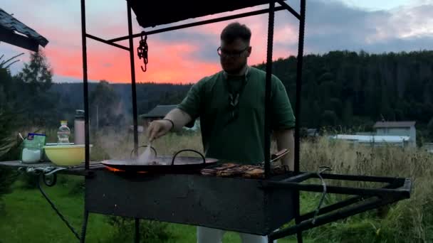 Mężczyzna Gotowanie Zewnątrz Grillu Zewnątrz Podwórku Zachód Słońca Nad Górami — Wideo stockowe