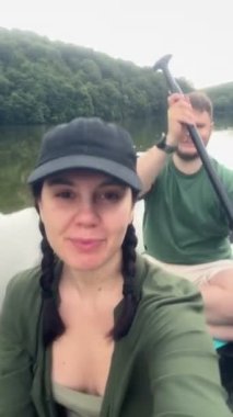 Nehir kenarında yüzen gülümseyen çift.