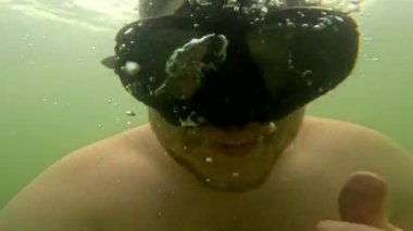 Scuba maskeli göl aktivitelerinde selfie çeken bir adam.