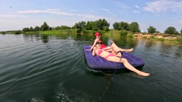 スーパーボードとマットレスの夏時間に浮かぶ湖で楽しんでいる友人 — ストック動画