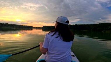 Gün batımında güvertede olan kadın göl aktiviteleri