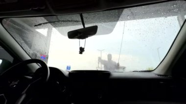 Araba yıkayan adamın içeriden görüntüsü