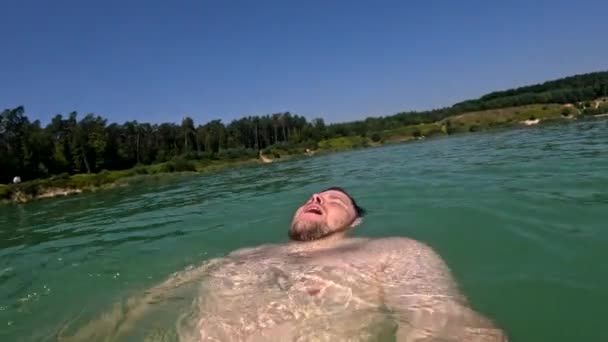 スーパーボードの夏の活動の近くの湖の裏に浮かぶ男 — ストック動画