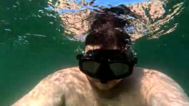 Dalgıç maskeli bir adam selfie alıp yaz tatilinde su altında yüzüyor.