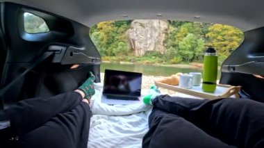 River Beach fotokopi alanının bagajında film izleyen çift.