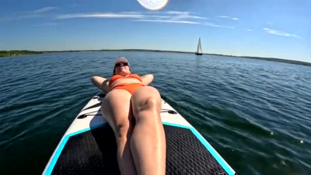 バックグラウンド夏の晴れた日にスーパーボードヨットで日光浴する女性 — ストック動画