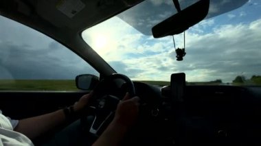 Güneşli bir günde direksiyondaki adam ellerini fotokopi makinesine koyar.