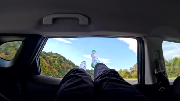 Mężczyzna Wystaje Nogi Samochodu Okno Zaparkowane Górach Rzeka Kamienista Plaża — Wideo stockowe
