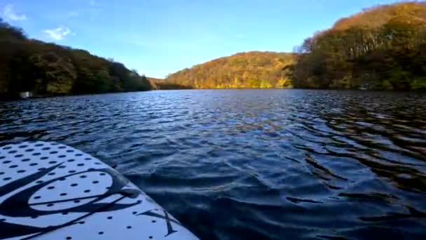 秋の色の森を背景のコピースペースで湖の上にスーパーボード — ストック動画