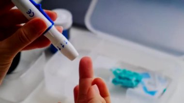 Şekeri ölçmek için kan alıyor. Yumuşak odaklanın.