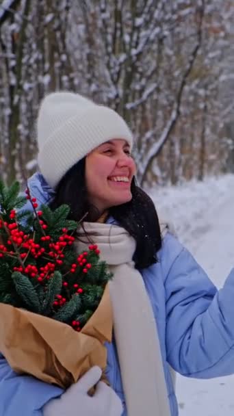 雪の森で松の木の花束と冬の衣装で美しい女性 — ストック動画