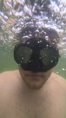 Scuba maskeli göl aktivitelerinde selfie çeken bir adam.