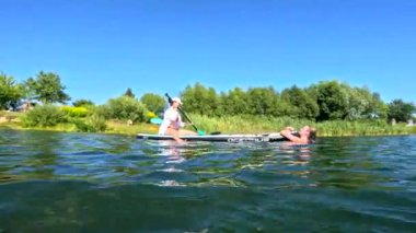 Mutlu arkadaşlar, temiz göl suyunda yüzerek güvertede suda eğleniyorlar.