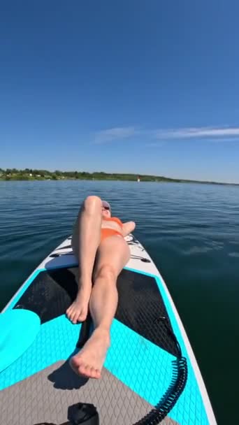 スーパーボードの夏の水活動に浮いている間 女性の日光浴 — ストック動画