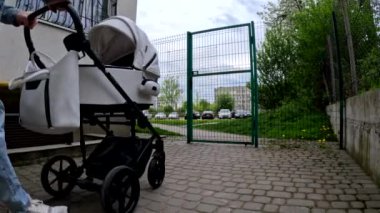 Şehir merkezindeki bir kapıdan bebek arabasını iten biri..