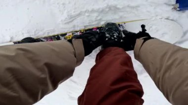 Snowboard kayışının Kar yamacında renkli tahtaya bağlandığını gören ilk kişi.