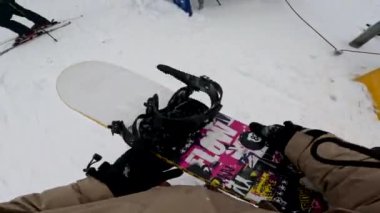 Snowboard kayışının Kar yamacında renkli tahtaya bağlandığını gören ilk kişi.