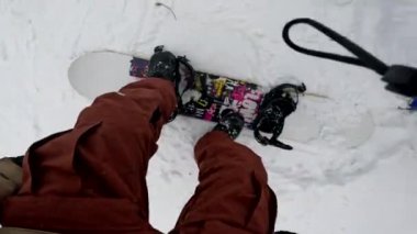 Snowboard kayışının Kar yamacında renkli tahtaya bağlandığını gören ilk kişi.