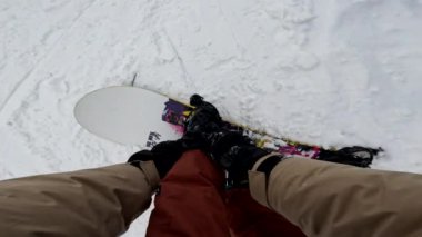 Snowboard kayışının Kar yamacında renkli tahtaya bağlandığını gören ilk kişi.