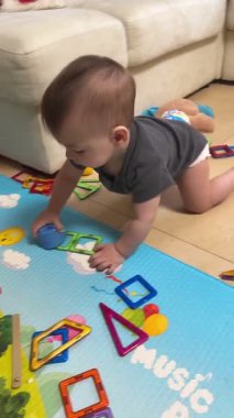 Renkli Oyun Mat 'inde Bebek Oturuyor