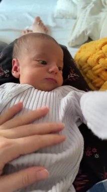 Yeni doğan bebek anne kucağında dinleniyor Sarı battaniye yakın çekim
