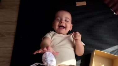 Gülümseyen Bebek Sırtüstü uzanıyor Oynuyor ve gülüyor