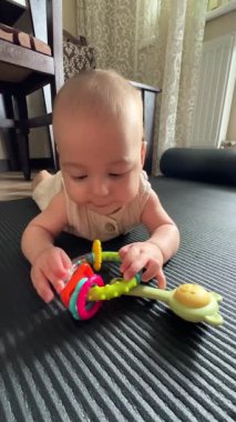 Mat 'te Renkli Oyuncaklarla Bebek Oynuyor