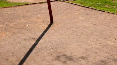 Çocuk, güneşli bahar gününde çocuk bahçesinde sallanıyor.