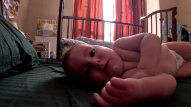 Bebek rahat bir odada yatağında uyuyor. Uyanıyor.