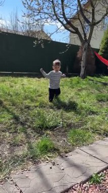 Güneşli bir günde Bahçede Yalınayak Yürüyen Bebek