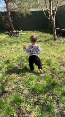 Güneşli bir günde Bahçede Yalınayak Yürüyen Bebek