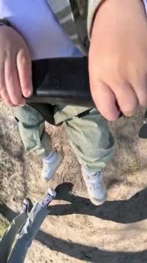 Yürüyen çocuk güneşli bir parkta salıncağın tadını çıkarıyor.