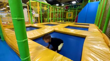 Çocuk Kapalı alanda Trambolinin tadını çıkarıyor.