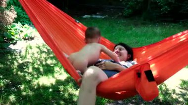 Anne ve Çocuk Bahçe 'de yaz mevsiminde Turuncu Hamakta Dinleniyor