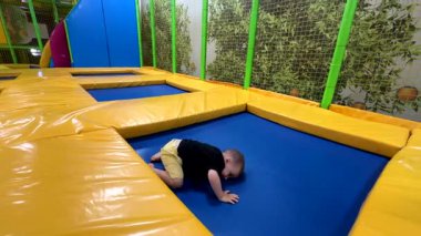 Çocuk Kapalı alanda Trambolinin tadını çıkarıyor.