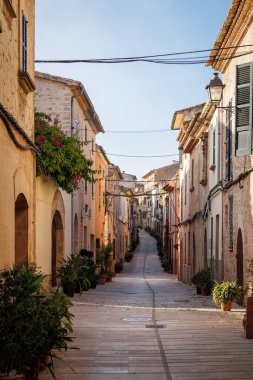 Alcudia Caddesi. Mallorca 'nın tipik bir kasabası. Dar bir caddesi ve saksı bitkileri var.