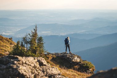 Dağ tırmanışı. Sırt çantalı bir kadın dağlarda yürüyüş yapıyor. Doğada macera ve keşif