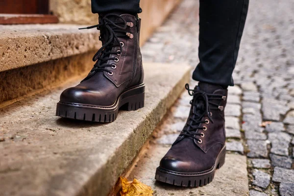 stock image Trendy black leather boots. Close-up stylish shoes. Female legs standing on staircase on street