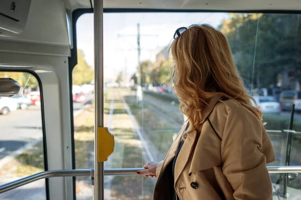 stock image Woman commuting to work by tram. Public transportation in city. Female commuter in tramway looking through window to street