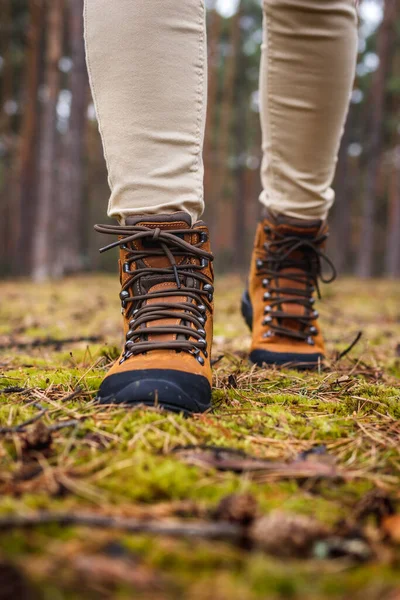 Tourist with hiking boots walking in forest. Waterproof leather ankle boot
