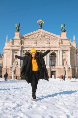 Lviv şehrindeki opera binasının önündeki mutlu kadın gezgin kış mevsimi kar yağdı