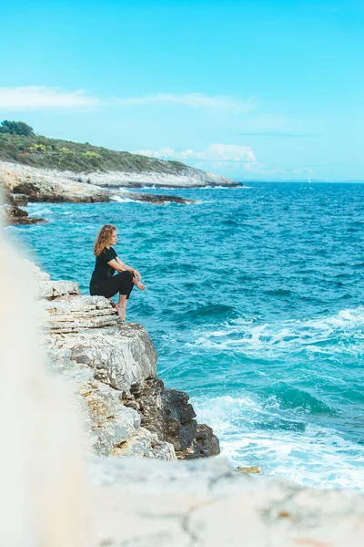 Genç Sıska Bir Kadın Uçurumun Kenarında Oturmuş Denize Bakıyor Boşluğu — Stok fotoğraf