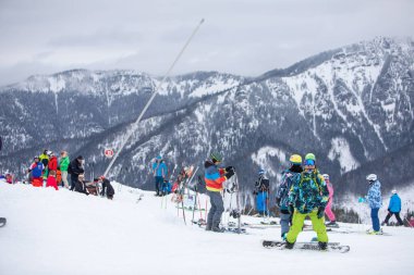 Slovakya, Jasna - 4 Şubat 2022: Kış Dağları, kayak merkezinin yamaçlarına bakıyor. Kayak yapan ve snowboard yapan insanlar fotokopi alanı