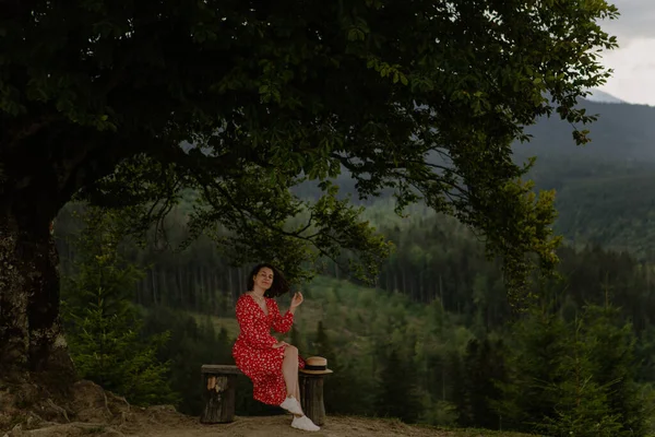 Young Woman Red Dress Sits Big Tree Mountains — Stock Photo, Image