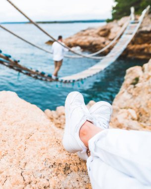 Resimli kadın bacakları uçurum süspansiyon köprüsünde üzerinde erkek olan arka plan fotokopi uzayı